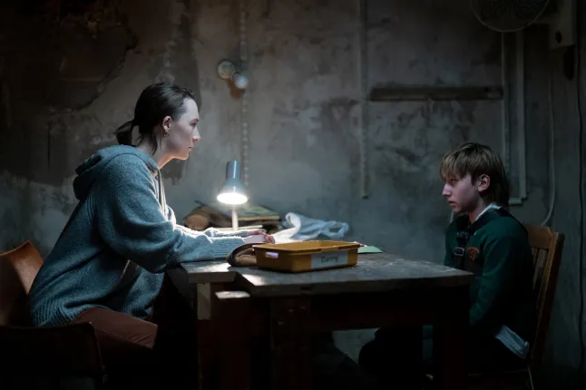 Maria with Daniel in an unfinished basement.